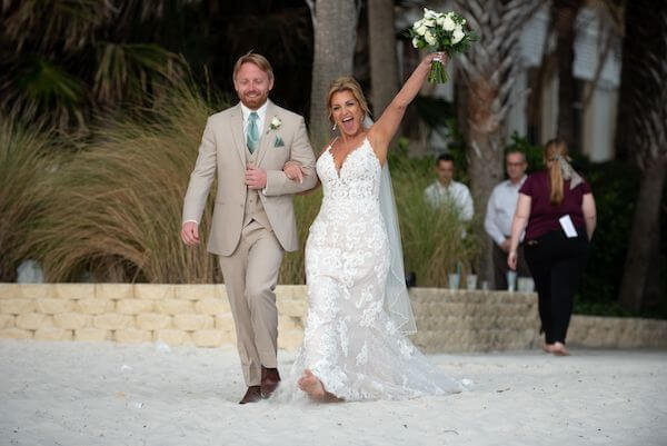 Excited bride walking down the aisle to her beach wedding ceremony