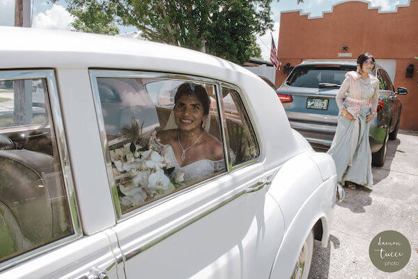 Bride and her father riding in a classic white Rolls Royce