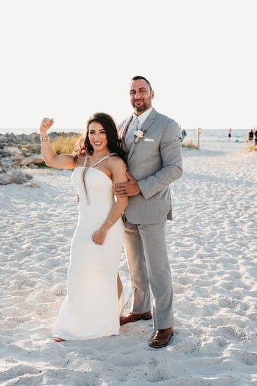 Bride and groom enjoying sunset photos on Clearwater Beach as the bride flexes!