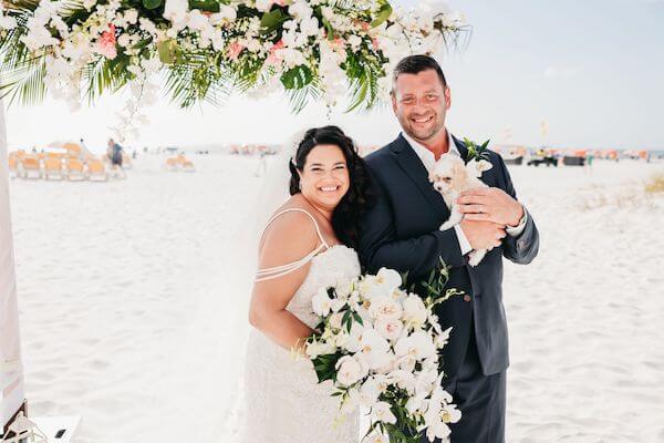 Bride and groom holding a puppy that was up for adoption during their cocktail hour