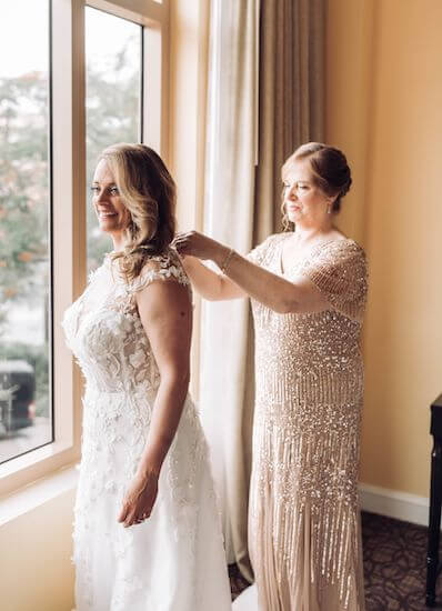 Mother of the bride helping her daughter get ready for her Clearwater Beach wedding