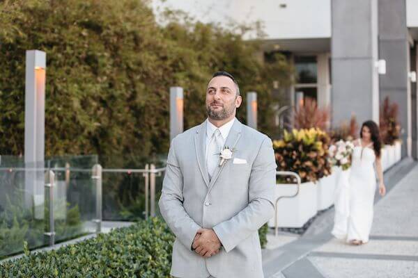 Groom waiting anxiously as his bride-to-be walks up behind him