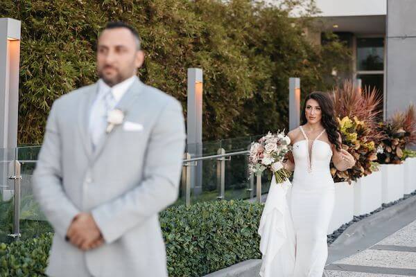 Bride-to-be walking up behind her groom for their first look