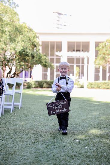 Ring bearer with a sign that says ¨Don't Worry, Ladies I'm still single.¨