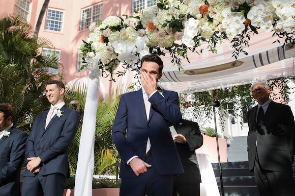 Groom crying as he sees his bride walking down the aisle at their Don Cesar wedding ceremony