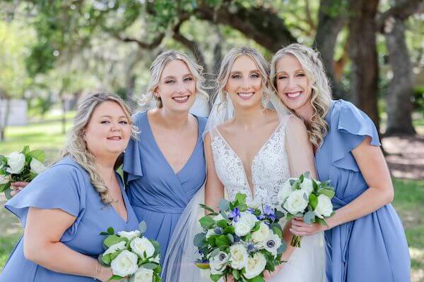 Bride with her bridal party wearing periwinkle dresses