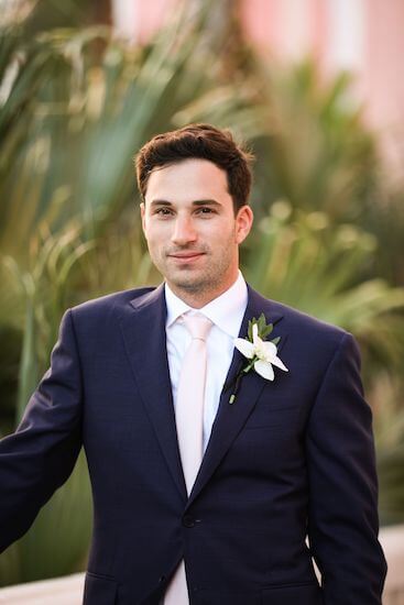 Handsome groom with a blue suit and pink tie