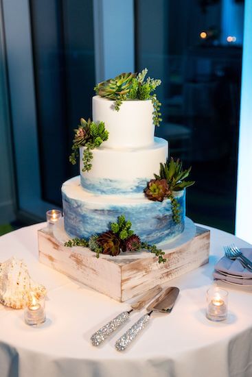 Three tiered white wedding cake brushed with ocean blue 