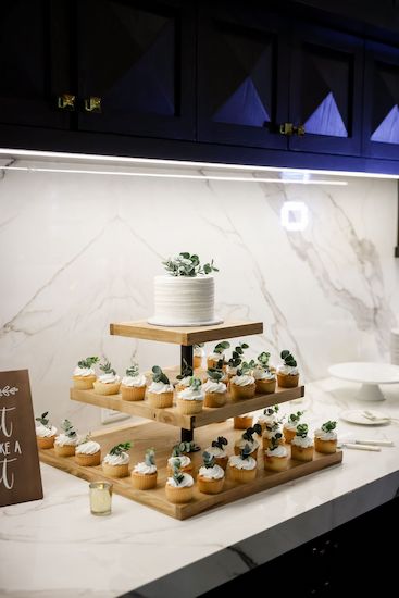 Intimate brunch wedding cake surrounded by cupcakes