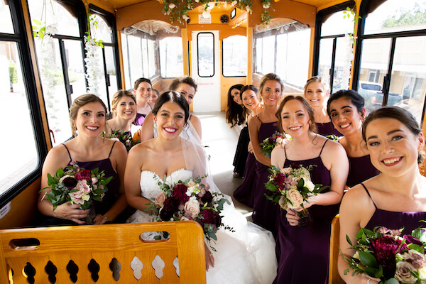 Bride and bridal party heading to church in a trolley