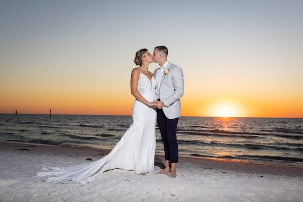 Bride and groom kissing on Clearwater Beach at sunset