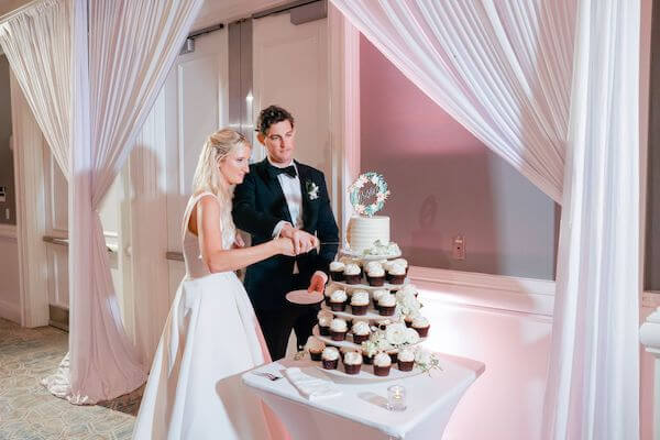 Bride and groom cutting an intimate wedding cake on a cupcake tower