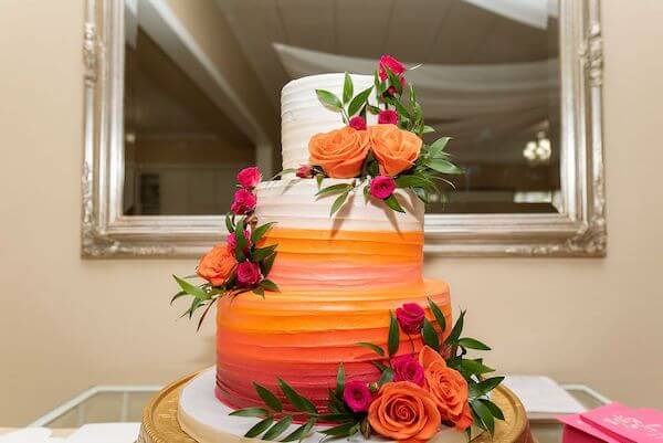 A modern white, orange and fuchsia ombre wedding cake