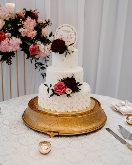 Three tiered white wedding cake at a Tampa Garden Club wedding reception