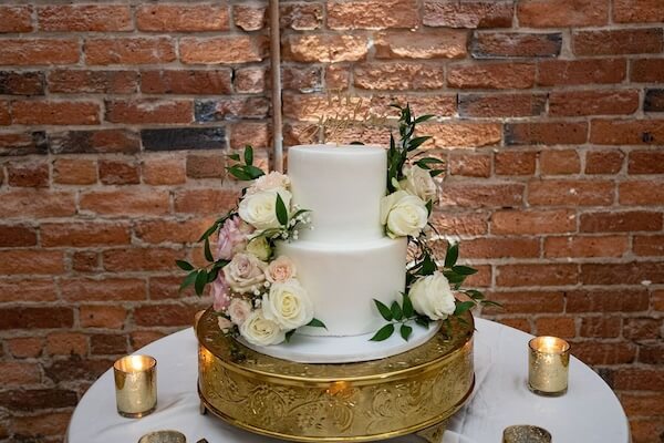 Two-tiered intimate white wedding cake on a guild riser