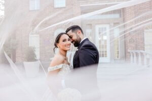 Bride and groom portrait wrapped in the brides'0s veil.