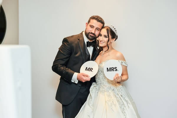 A bride and groom taking photos in a Photo Booth.