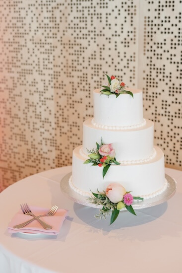 Three tiered white wedding cake with pink flowers at the Tampa River Center