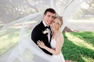 Bride and groom wrapped in a veil