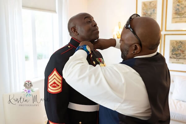 Groom dressing in his dress blue uniform.