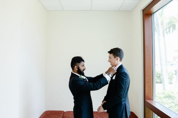 Groomsman helping the groom get dressed