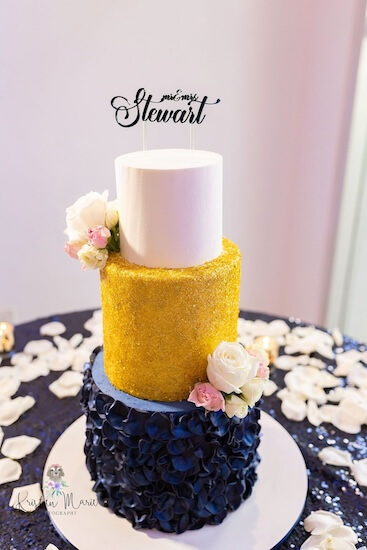 Three tiered white, cold and navy wedding cake