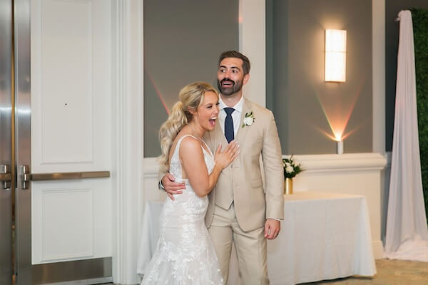 Excited bride and groom taking a sneak peek at their reception decor.