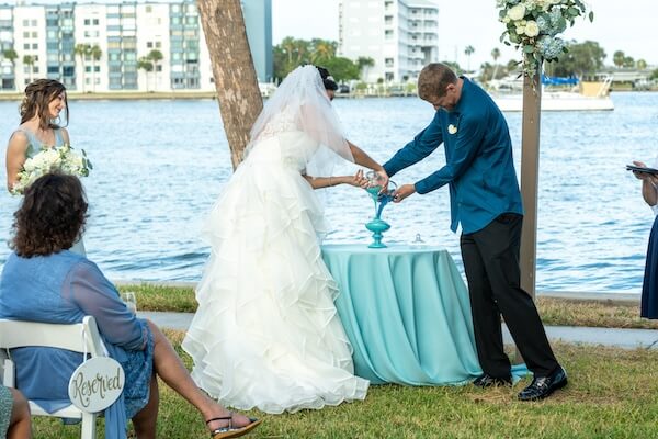 Beach- themed wedding ceremony with a sand ceremony