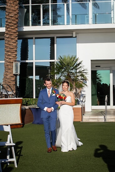 Bride walking down the aisle at the Opal Sands, escorted by her brother.