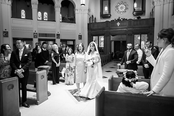 Bride, escorted by her mother walking down the aisle.