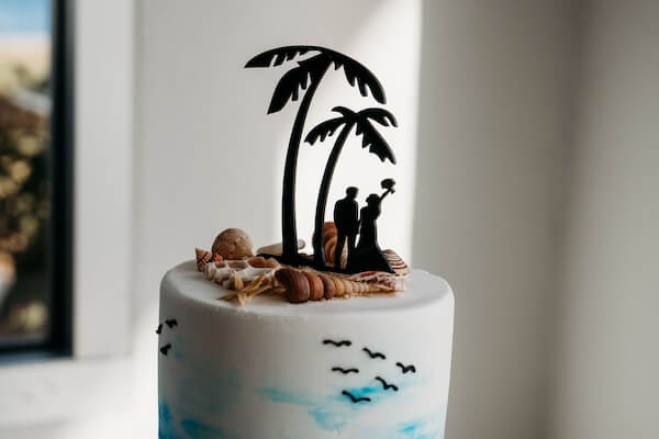 Beach-themed wedding cake and custom topper