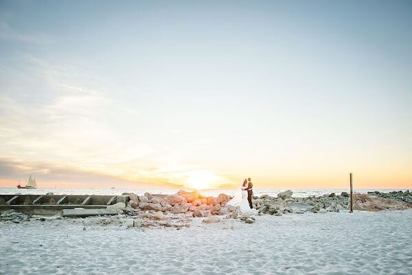 Newlywed couple on Clearwater Beach at sunset.