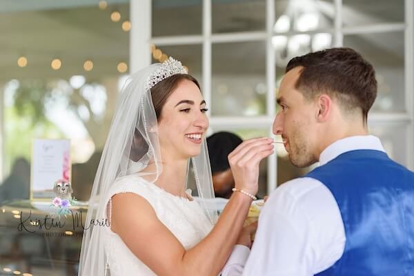 A bride and groom sampling gelato at their afternoon wedding reception.