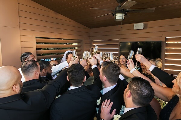 A wedding party toasting with the newlyweds after thier wedding ceremony.