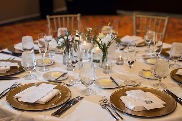 Place settings in white and green with gold accents.