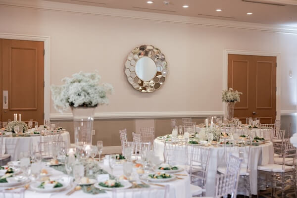 A white, gold, and sage wedding reception overflowing with baby's breath.