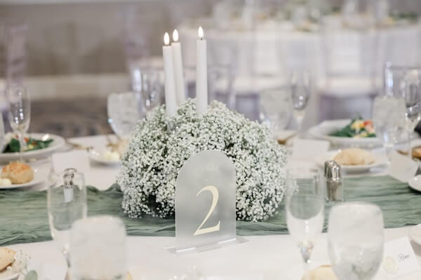 A white, gold, and sage wedding reception overflowing with baby's breath.