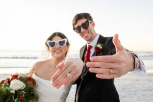 The bride and groom on Clearwater Beach are showing their new wedding rings.