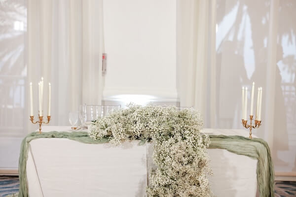 A sweetheart table overflowing with baby's breath.