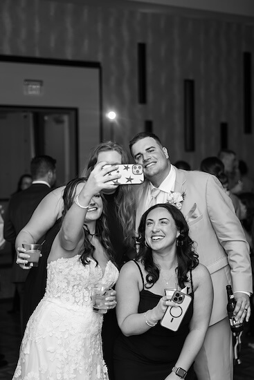 Bride and groom taking a selfie with friends.