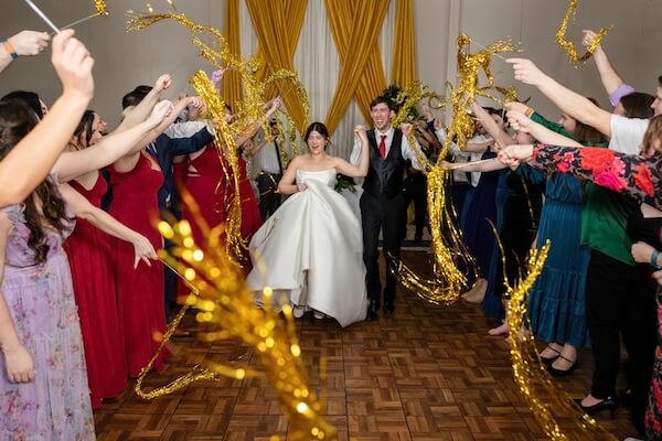 The bride and groom party under gold streamers at their Clearwater wedding