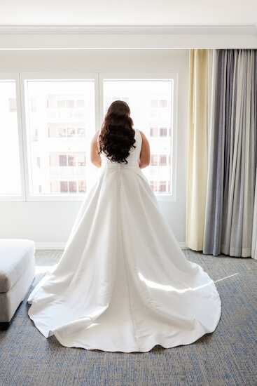 A bride looking out the widow beopfre her Sky Terrace wedding.