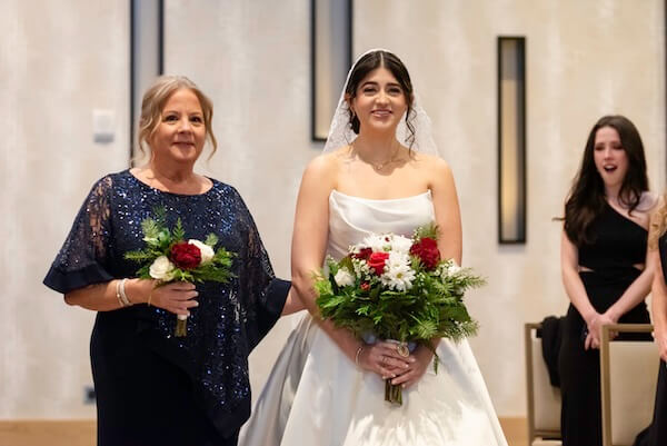 A bride walking down the aisle with her mother at her Clearwater wedding ceremony.