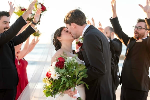 A newlywed couple and their wedding party are having some fun on Clearwater Beach.