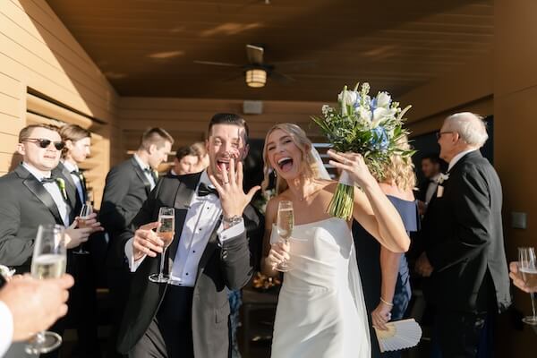 Just Married! A newlywed couple sipping champagne and showing off their new wedding rings.