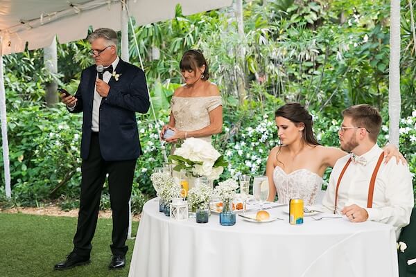 Parents of the bride welcome guests to their daughter's wedding.