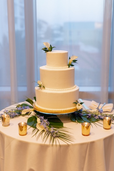 A sleek, white, three-tiered wedding cake.