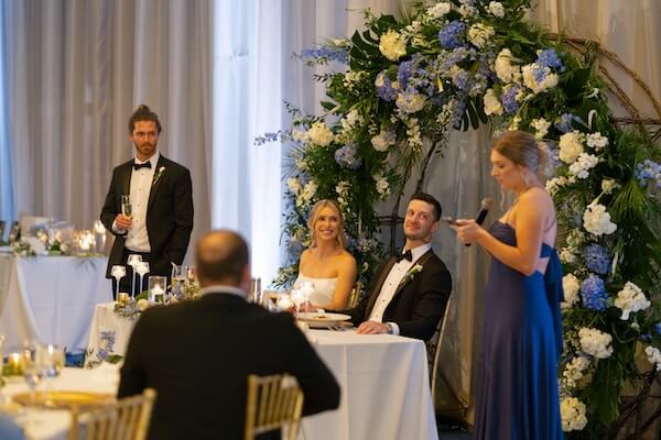 A best man and maid of honor sharing toasts at an Opal Sands Resort wedding reception.
