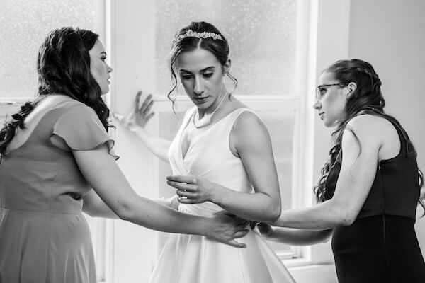 A wedding party helping a bride dress for her St. Pete wedding.