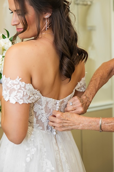 Mom helping her daughter with her wedding gown.